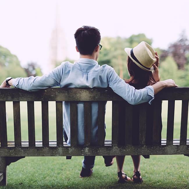 Rear view of a man and a woman sitting on a bench