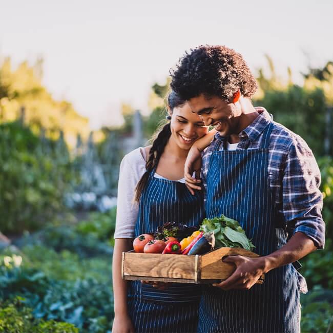 Couple holding a tray of fruits and vegetables