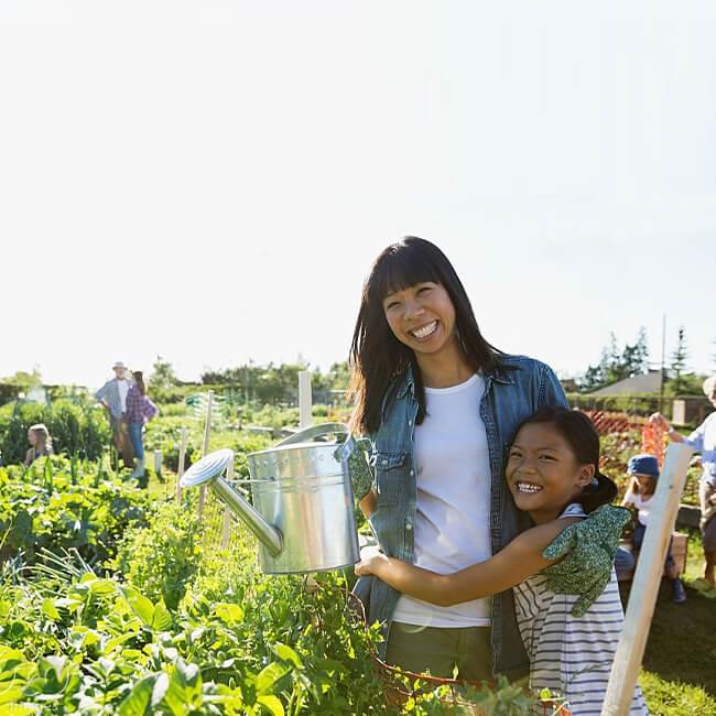 Mother and daughter watering plants