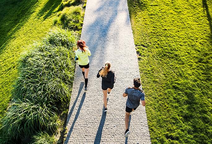 Overhead view of 3 people jogging on a pathway
